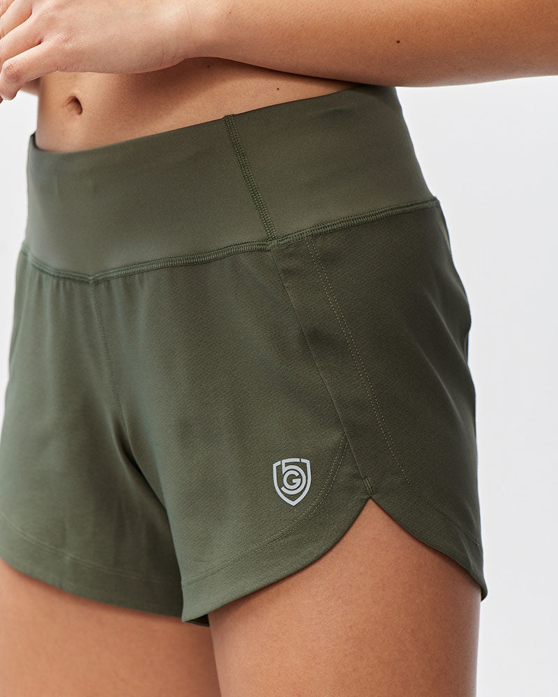 Excel Women's Workout Shorts by Goal Five, dark moss training shorts shown from side view.