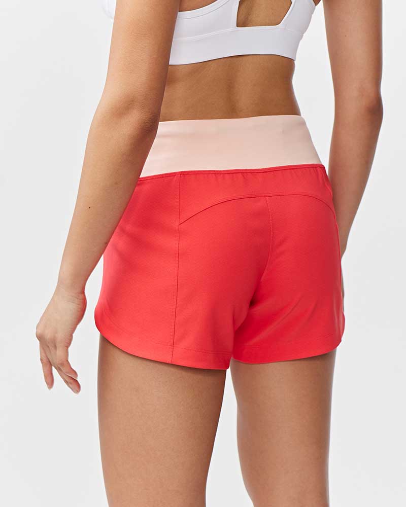 Back view of Excel Women's Workout Shorts by Goal Five in hot coral nectar, designed for training and exercise.