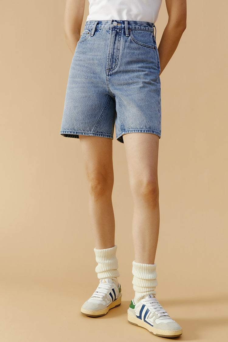Hey Joanie Angeles High Rise Shorts in denim with a fitted waist and distressed details, displayed on a hanger.