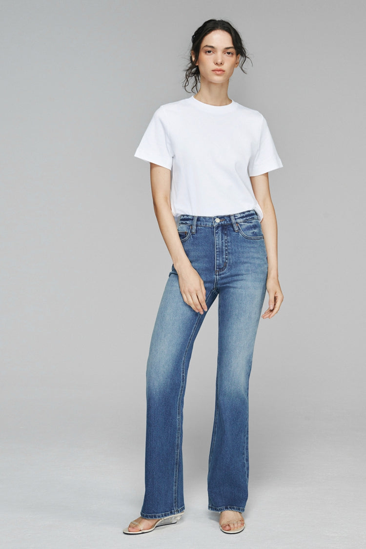 Hey Joanie Barbara high rise bootcut jeans with faded denim and classic five-pocket design on a model.